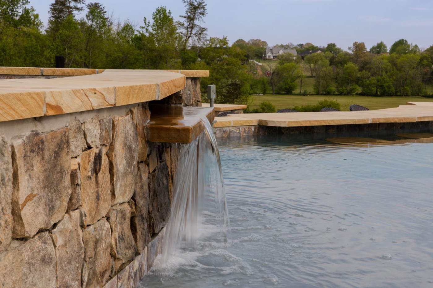 Stone pool decking beside a gunite pool