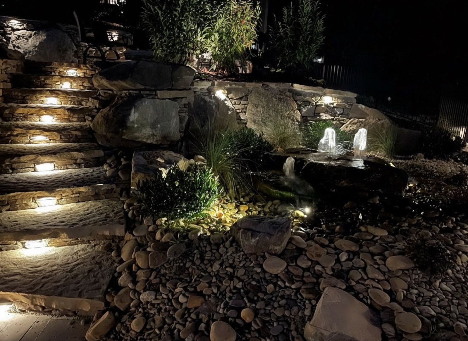 Natural stone steps with warm lighting set into every riser at night